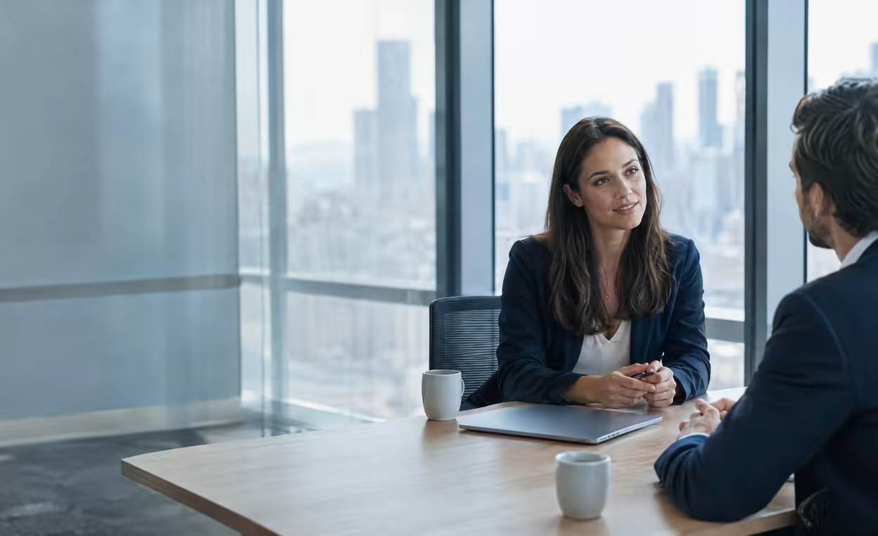 A Northstar consultant interviewing a candidate across a table in a glass-walled meeting room.