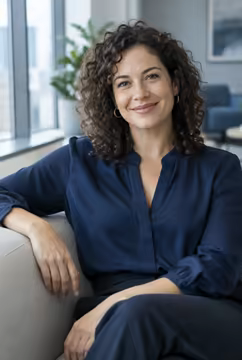 A hiring manager with curly hair, smiling.
